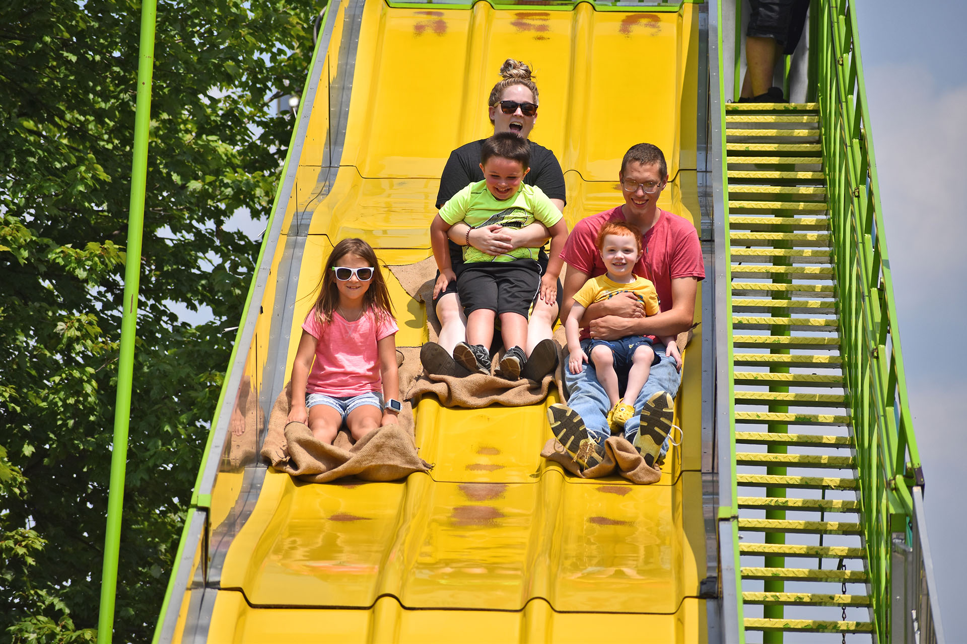 Family riding the big slide at the Seneca County Fair.
